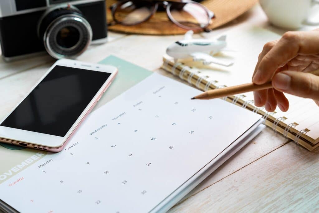 Person writing on a calendar at a desk.