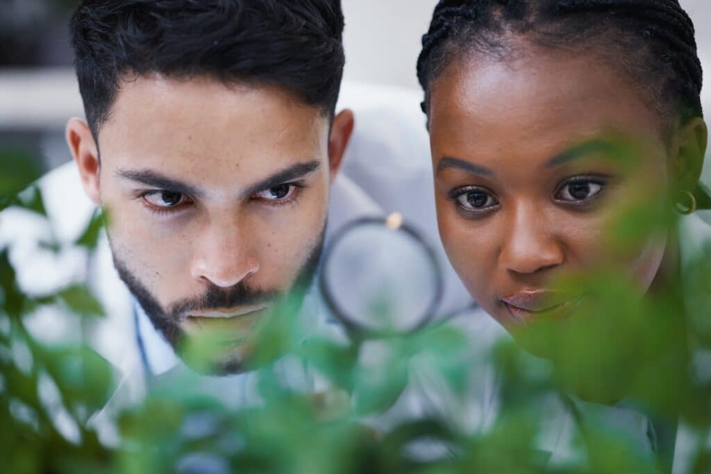 Two people looking through magnifier glass.