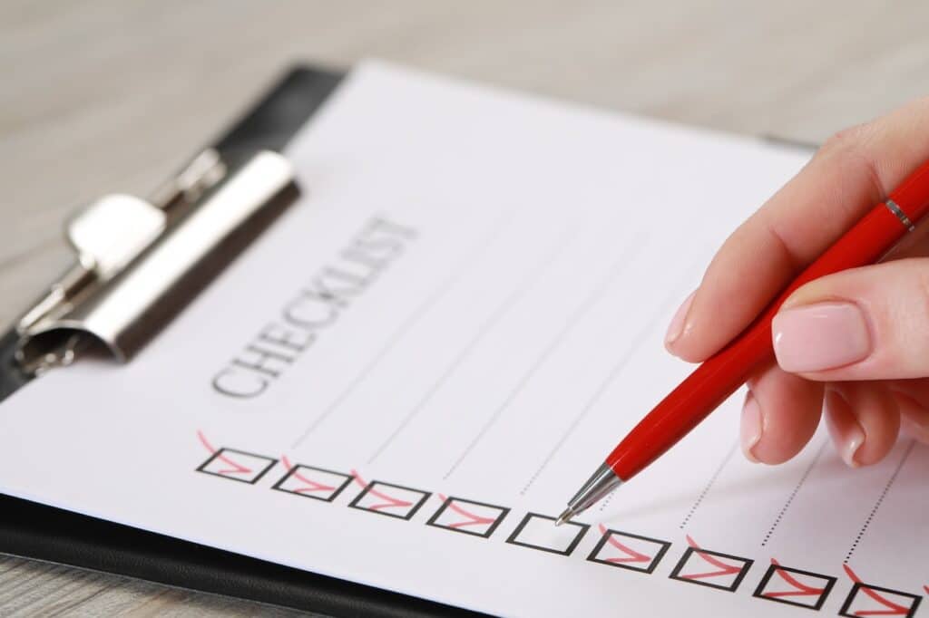 Woman filling out a checklist with red pen
